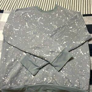 Grey sweat shirt styled with white paint spots.